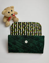 Load image into Gallery viewer, Green quilted clutch with holly patterned interior and teddy bear on a white background. a metal snap for closurer