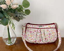 Load image into Gallery viewer, Floral-patterned handbag on a wooden surface with a vase of flowers.