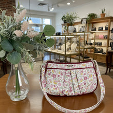 Load image into Gallery viewer, Floral-patterned handbag on a wooden surface with a vase of flowers.