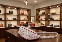 Load image into Gallery viewer, Floral-patterned bag on a wooden surface with a vase of flowers in the background