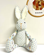 Load image into Gallery viewer, Stuffed rabbit toy with patterned fabric on a white background, with a patchwork hoop in the background.